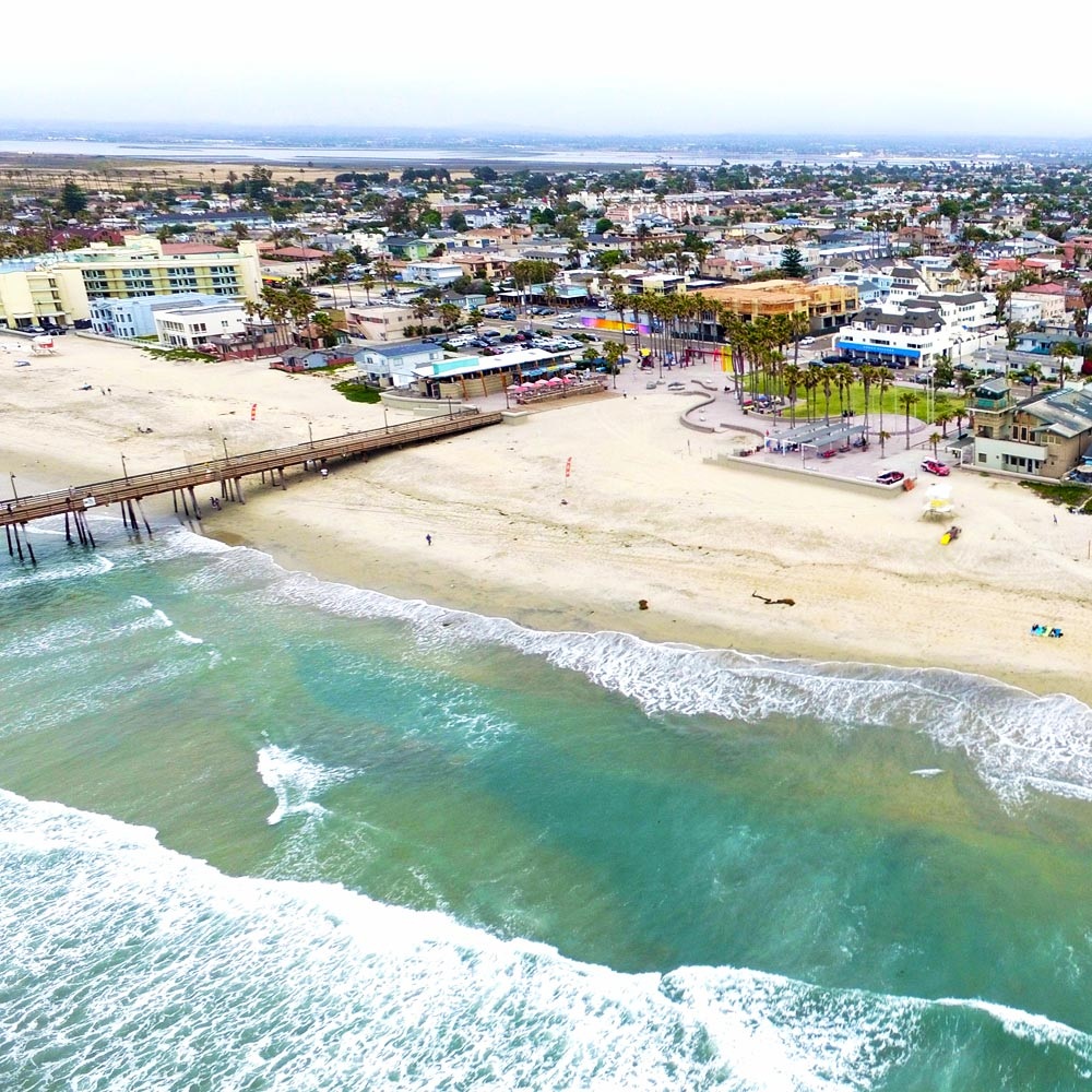 Cleaner removing sand and wiping surfaces in occupied coastal Imperial Beach home
