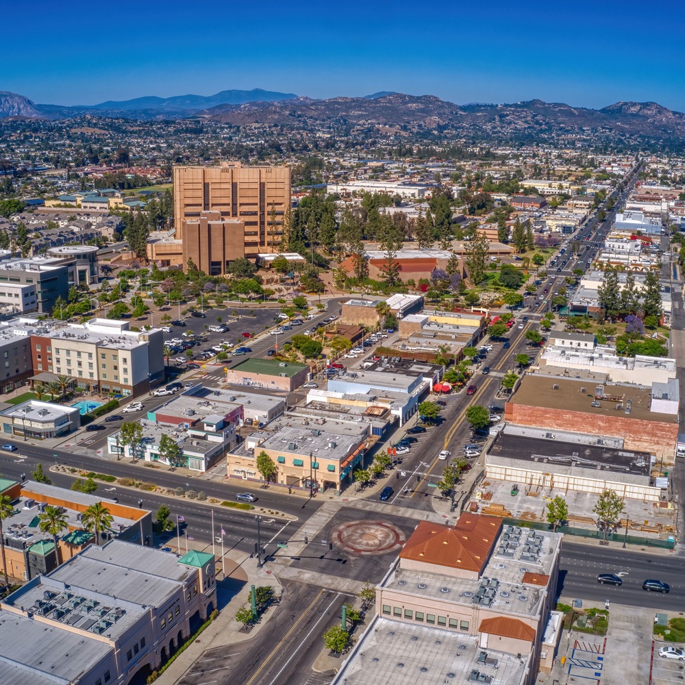 Cleaner wiping kitchen counters and fixtures in busy La Mesa family home