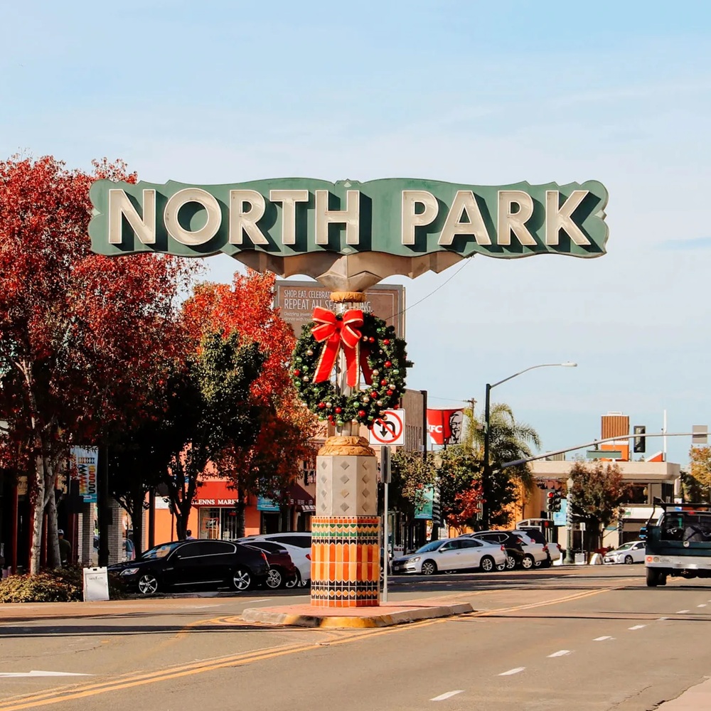 Cleaner wiping kitchen counters and finishing bathroom details in occupied North Park apartment