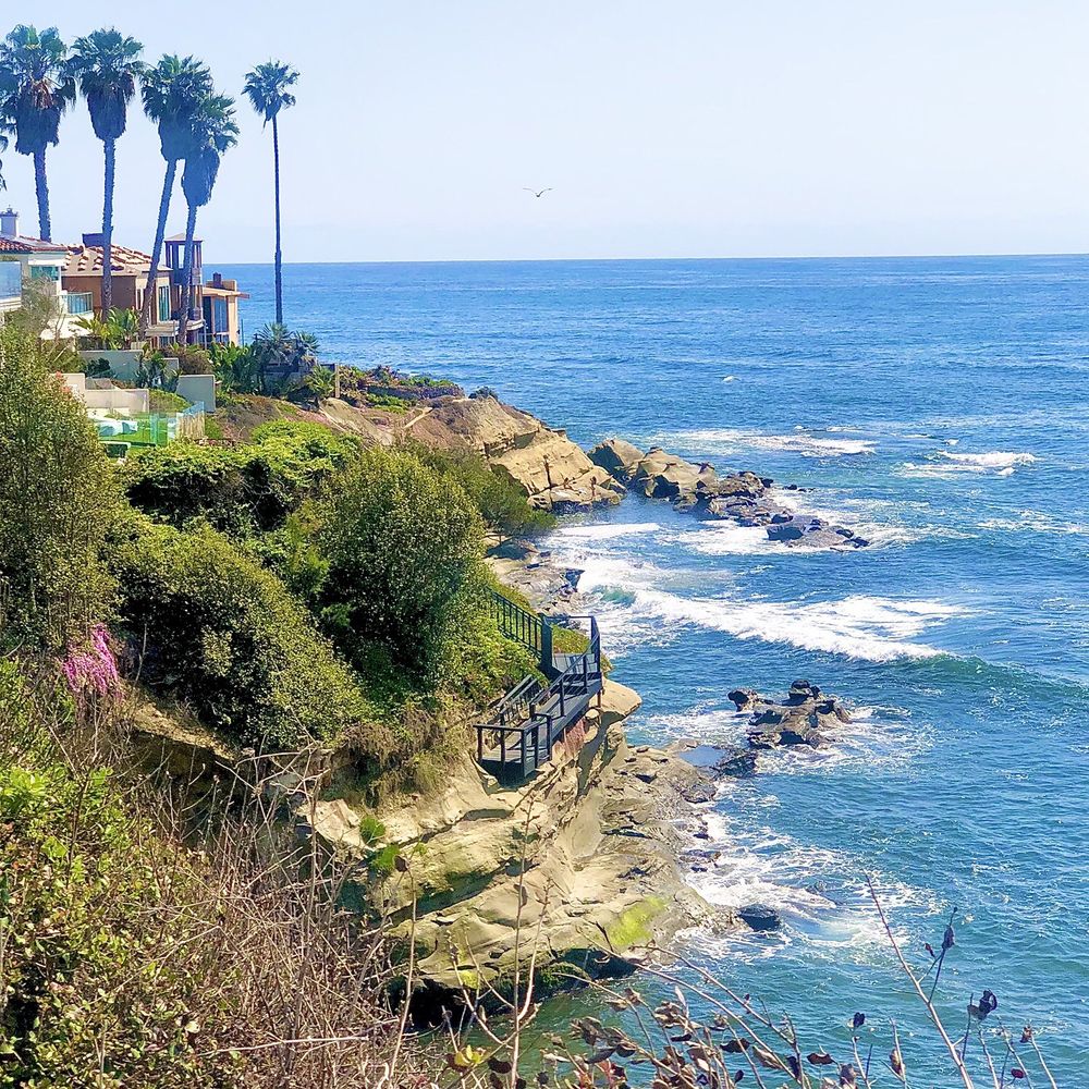 Cleaner wiping kitchen counters in lived-in Point Loma family home